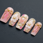 Macro close-up 3D gold bow charm pearl flower custom press-on nails dramatic lighting — LuxepressCo