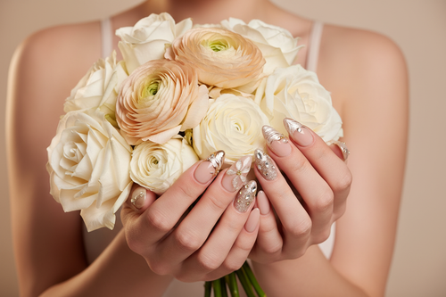 Light skin hands holding white roses champagne ranunculus wearing champagne pearl custom press-on nails — LuxepressCo