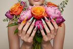 Fair-skin hands wearing Y2K fantasy stiletto custom press-on nails holding colorful flower bouquet — LuxepressCo