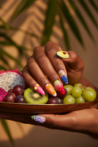 Dark skin hands wearing exotic fruit paradise 3D custom press-on nails holding luxury exotic fruit platter with dragon fruit grapes kiwi — LuxepressCo