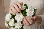 Fair-skin hands wearing ocean shell gold starfish pearl abalone custom press-on nails holding white gardenias — LuxepressCo