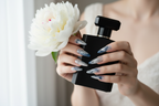 Lifestyle light skin hands wearing ink calligraphy jelly custom press-on nails holding white peony — LuxepressCo
