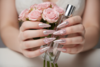 Lifestyle light skin hands wearing pink fortune angel wing custom press-on nails holding blush roses — LuxepressCo
