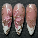 Macro close-up hand-painted pink magnolia gold filigree pearl rhinestone custom press-on nails dark background — LuxepressCo