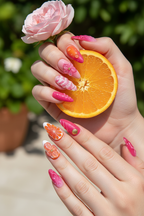 Fair skin hands wearing pink orange swirl 3D floral custom press-on nails holding orange slice and pink rose — LuxepressCo