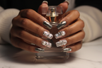 Dark-skin hands wearing silver chrome liquid metal holographic plaid custom press-on nails holding perfume — LuxepressCo