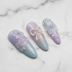 Macro close-up 3D bow ribbon floral custom press-on nails pastel blue lavender glossy texture — LuxepressCo